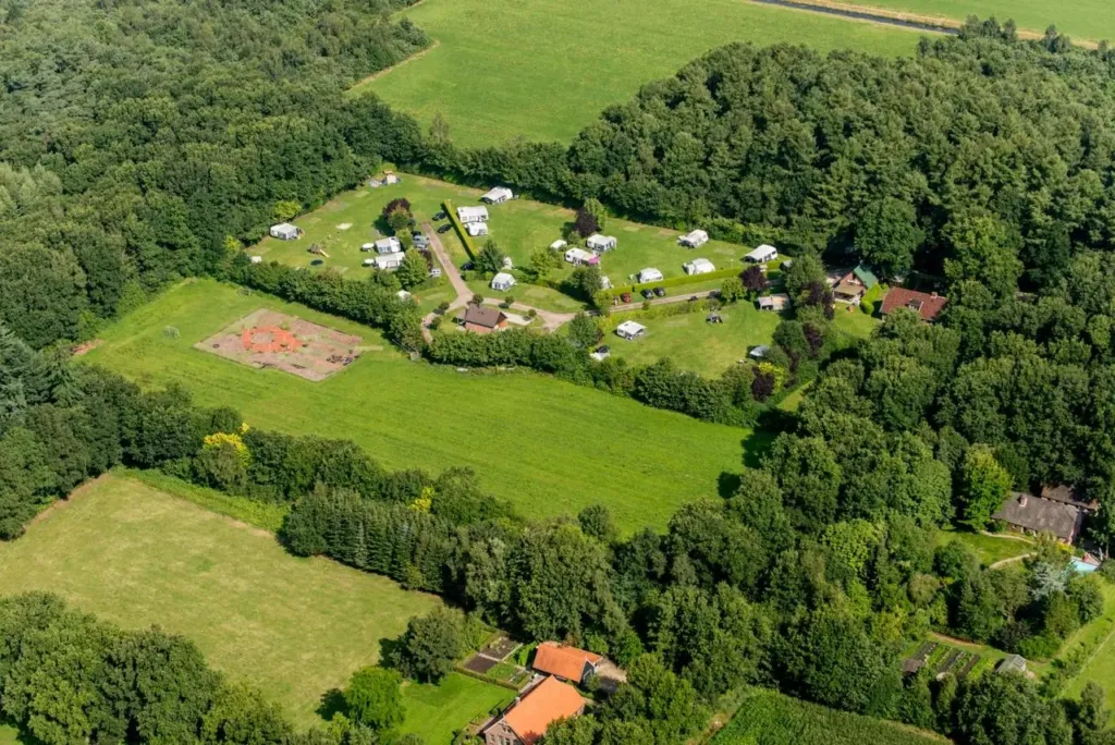 Luchtfoto van Camping Hollandscheveld: kampeervelden met hagen, omringd door bos en weilanden
